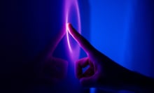 A finger taps a glowing purple and blue touch screens 