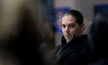 Starbuck sits at a conference table. 