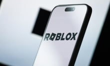 A phone screen shows a black and white Roblox 