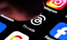 a finger pressing the threads icon on a phone