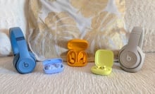 The Beats Studio Pro, Beats Fit Pro, Beats Solo 4, Beats Solo Buds, and Beats Powerbeats Pro 2 next to each other on a sofa.