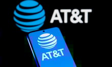 A phone displays the blue AT&T logo in front of a dark background.