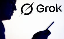 A silhouette of a person reading on a phone in front of the Grok logo.
