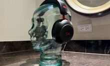 Pair on headphones sitting on a clear glass head bust