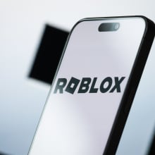 A phone screen shows a black and white Roblox 