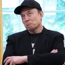 Elon Musk appears in the Oval Office wearing a Doge hat
