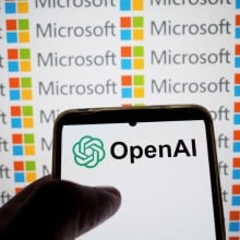  OpenAI logo appears on a smartphone screen and the Microsoft logo on a laptop screen 