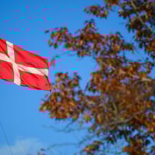 The danish flag is flying upon a state government building