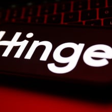 A laptop keyboard and Hinge logo displayed on a phone screen