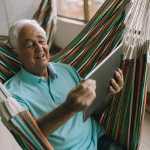 Man looking at laptop from hammock