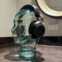 Pair on headphones sitting on a clear glass head bust