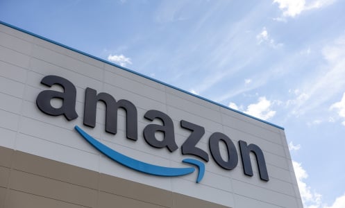 A large Amazon logo sign on the side of a warehouse.