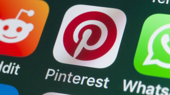 The buttons of the app Pinterest, surrounded by Reddit, Whatsapp, Skype and other apps on the screen of an iPhone.