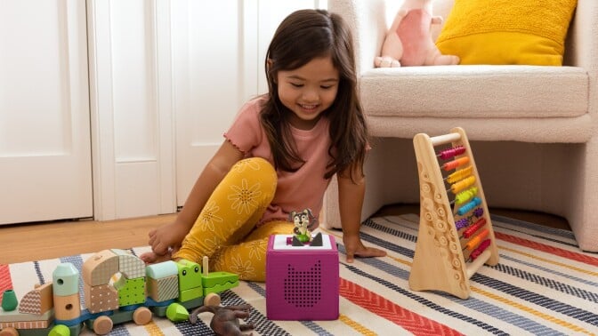 girl sitting on floor near toys
