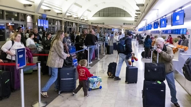 Travelers wait to check bags at the start of the Thanksgiving holiday at John Wayne Airport in Santa Ana, CA on Monday, November 24, 2025. The Auto Club projects 6.78 million residents in Southern California will travel 50 miles or more from home during the Thanksgiving holiday travel period, marking a 2.8% increase over last year and setting a new record for this holiday.