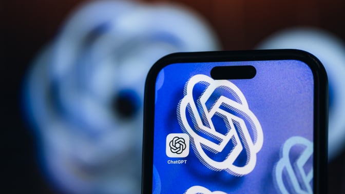 Photo illustration of the chatgpt logo on a smartphone. The same logo can be seen faded in the background