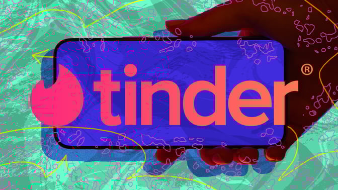 hand holding phone with tinder logo
