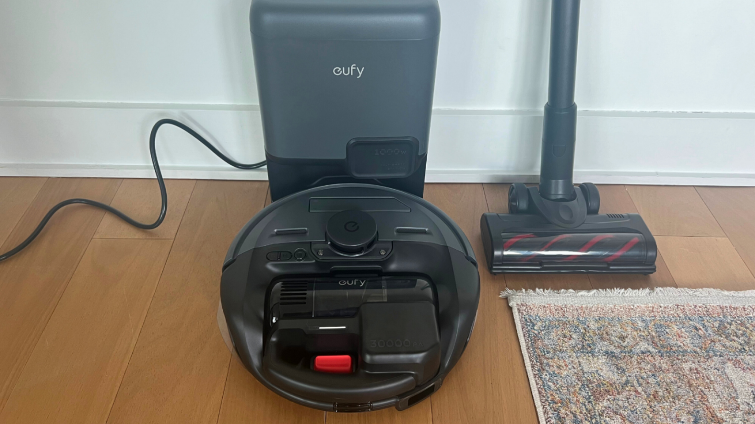 the Eufy E20 3-in-1 Robot Vacuum against a wall next to a rug