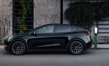 A black Tesla Model Y, parked on a street.