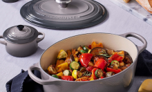 Gray Le Creuset casserole dish with vegetables insideq