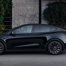 A black Tesla Model Y, parked on a street.