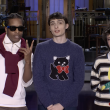 Two men and a woman stand facing the camera.