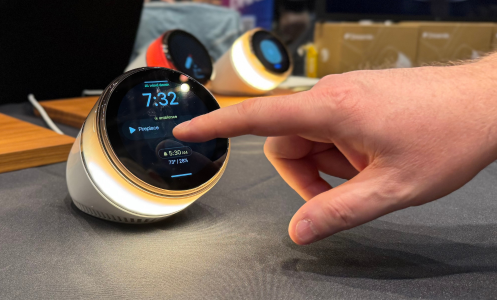 a man's hand tapping the screen of an ambient dreamie smart sunrise alarm clock