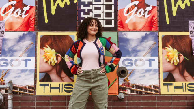 Woman in front of wall standing defiantly