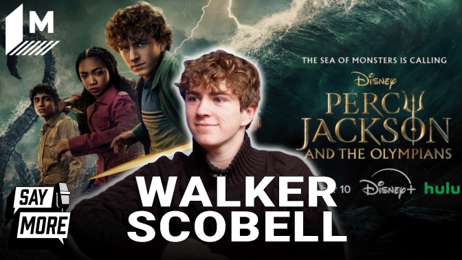 Walker Scobell against a backdrop of the poster for "Percy Jackson and the Olympians" Season 2.