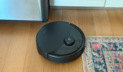 Roborock Q10 S5+ robot vacuum cleaning rug and hardwood floor in kitchen